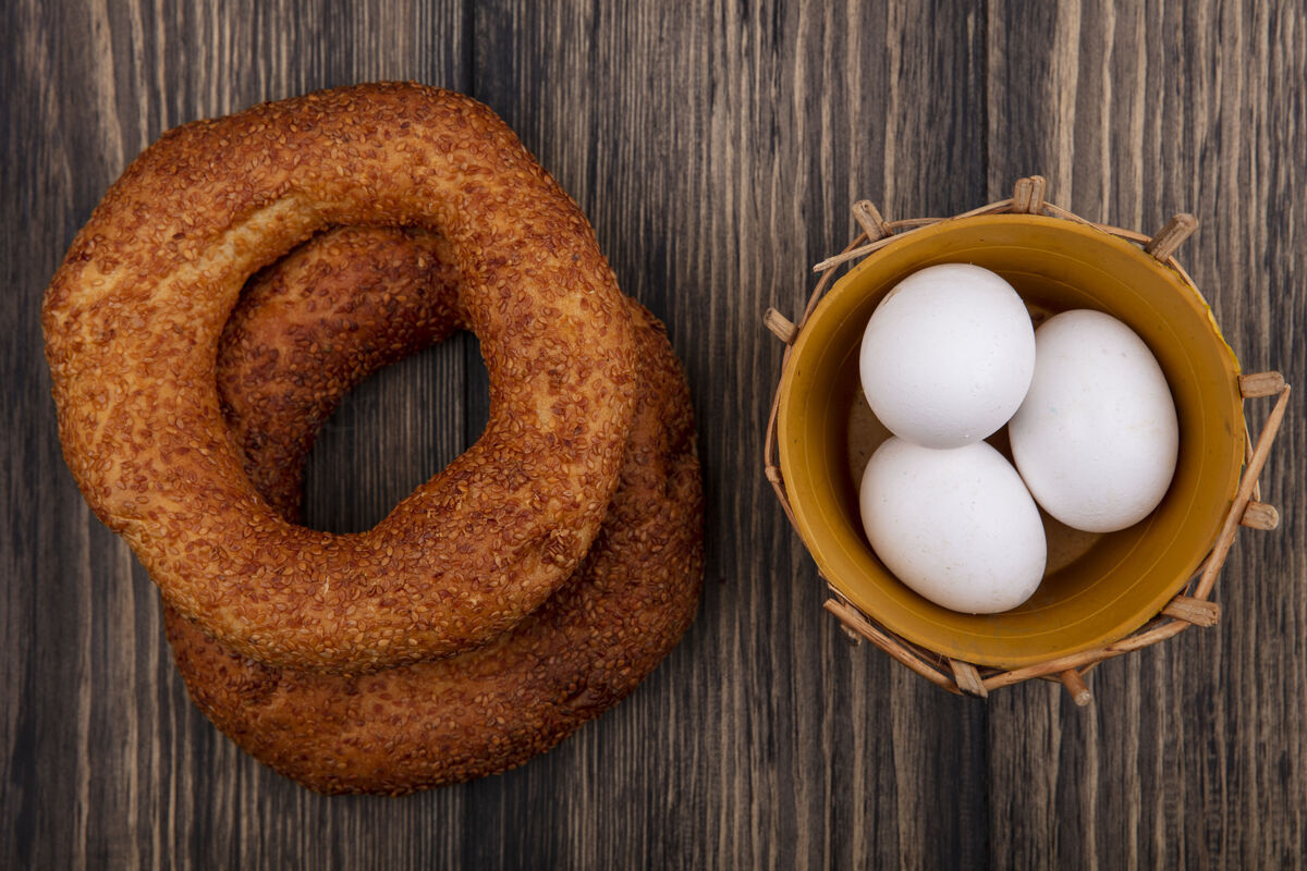 早餐木制背景上的桶上有美味柔软的土耳其百吉饼和鸡蛋的顶视图膳食百吉饼美味