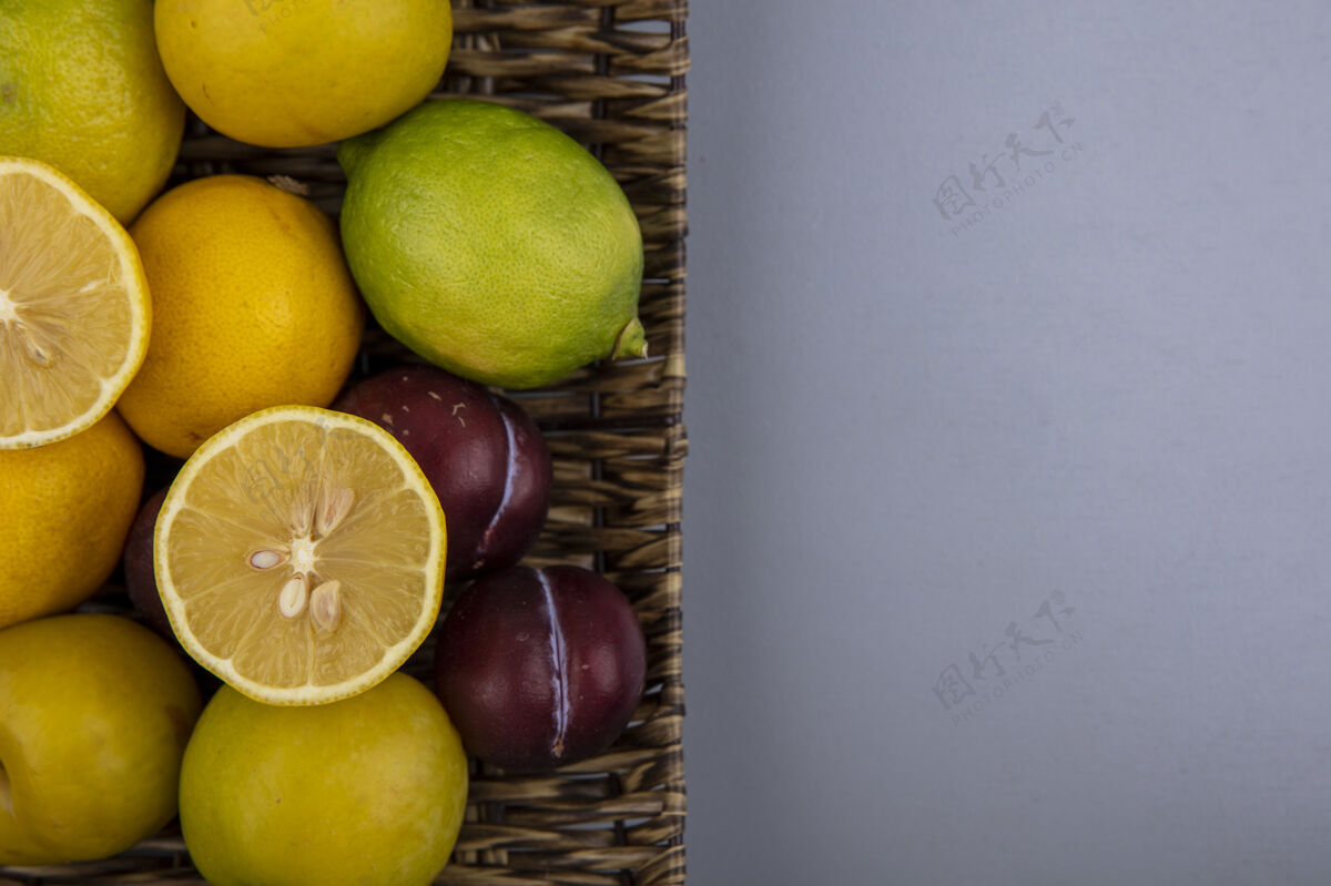 空间新鲜柠檬与李子和樱桃李子桶顶视图在灰色背景与复制空间柠檬新鲜顶部