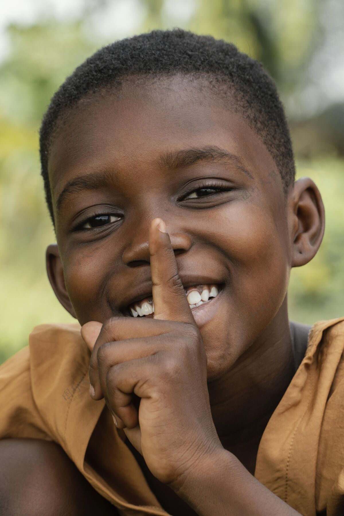 男孩肖像笑脸年轻的非洲男孩做沉默的迹象肖像孩子非洲人