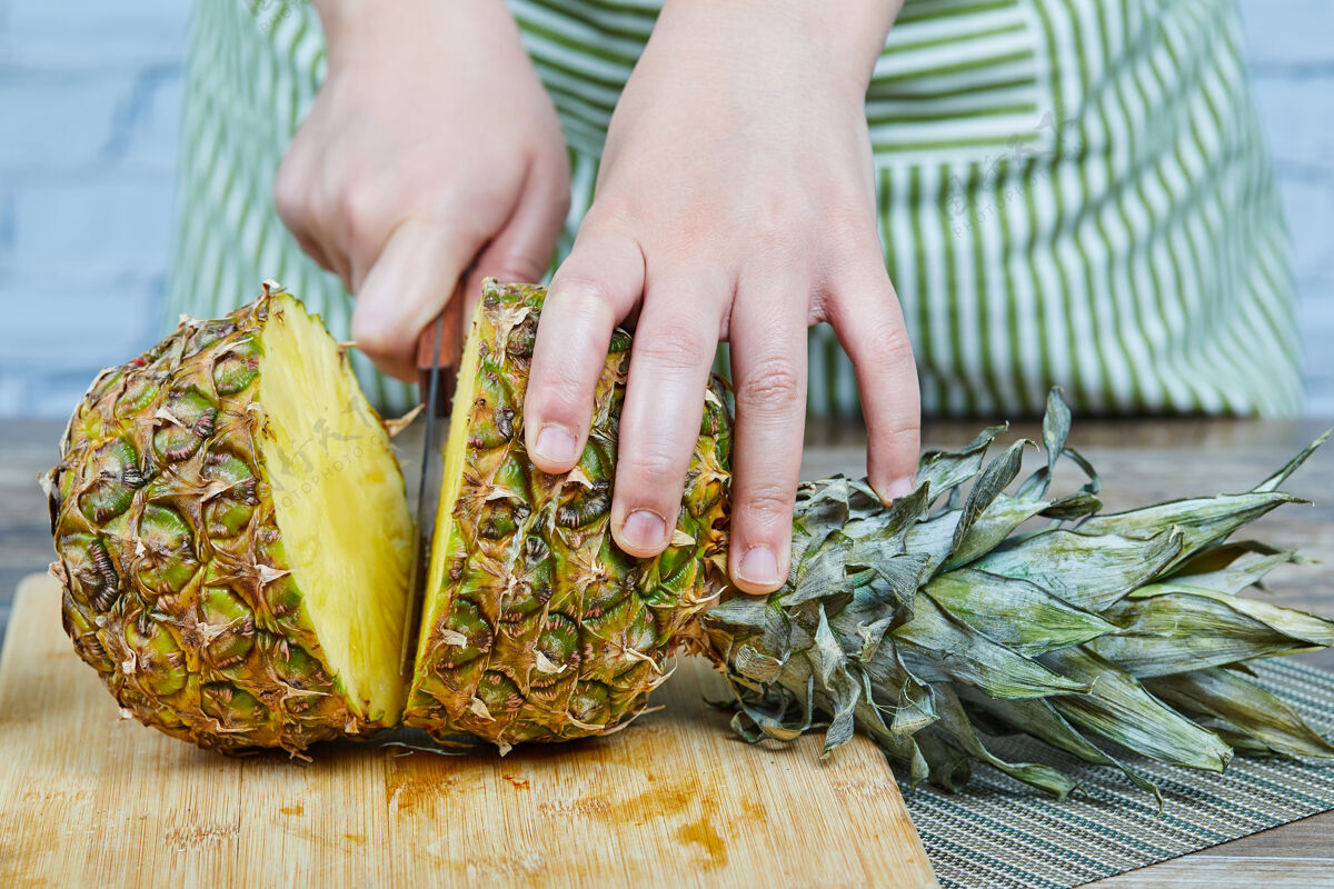 甜在木头砧板上切菠萝的人新鲜美味菠萝