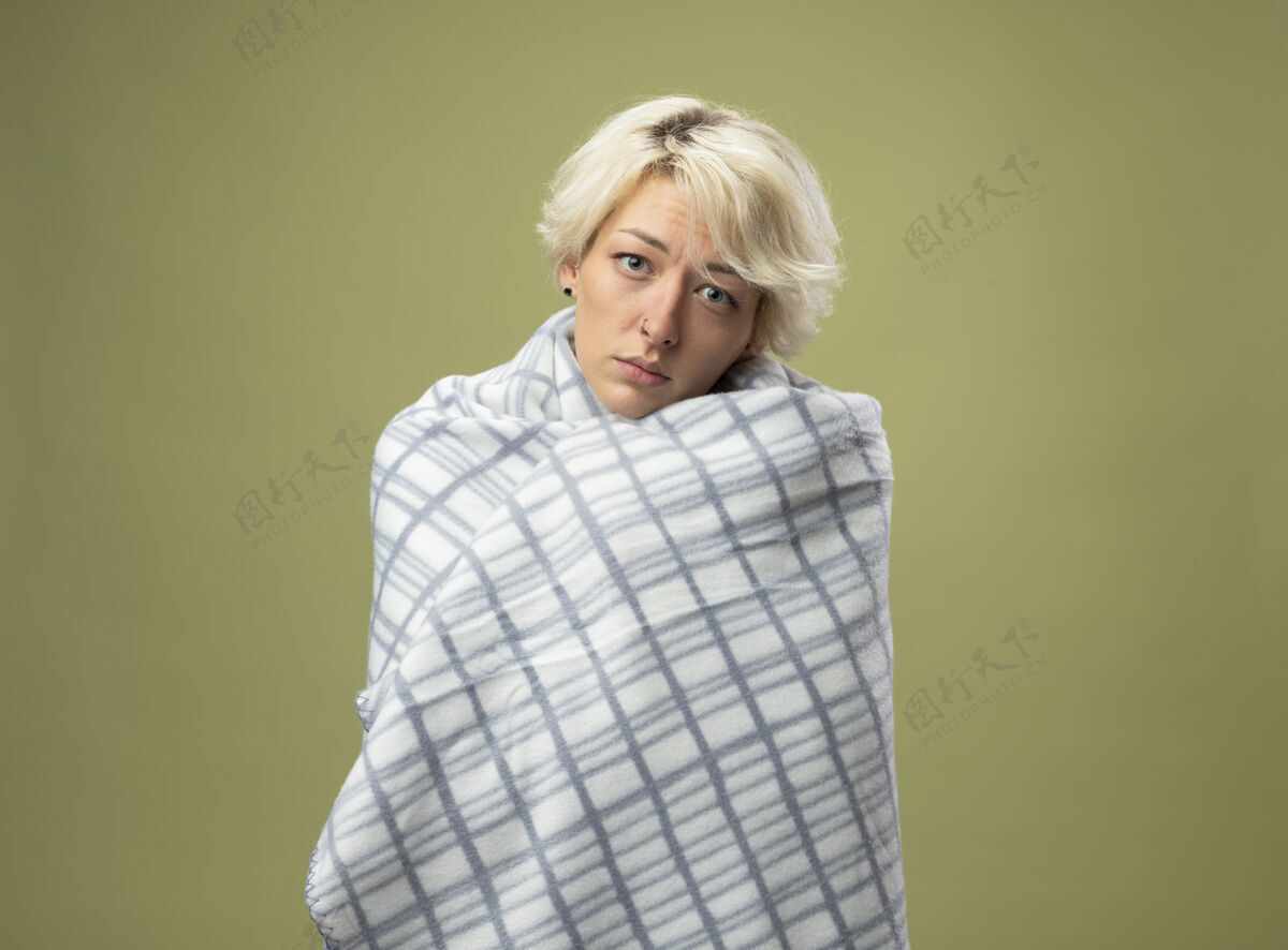 不健康生病的不健康的女人 短发感觉不舒服 裹在毯子里 站在轻质的墙壁上 看起来像患了流感头发痛苦女人