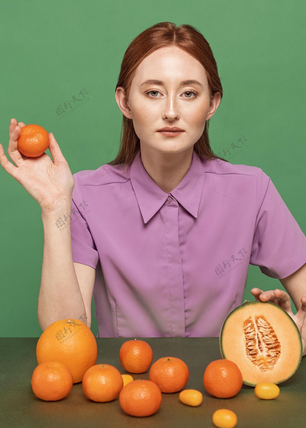 美味美丽的红发女人摆着橘子的姿势营养美味食物