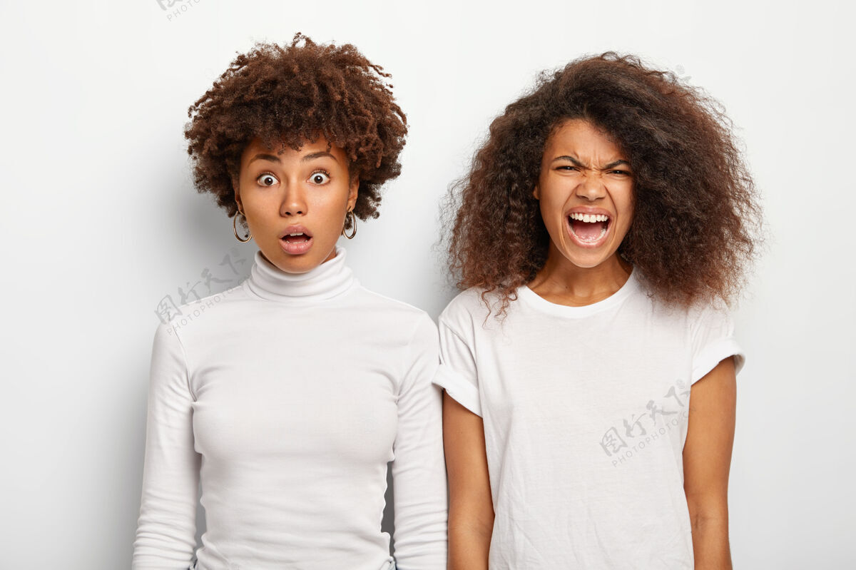 恼怒两个非洲裔美国姐妹对一些不好的事情做出反应 其中一个呆呆地望着惊奇女性时髦