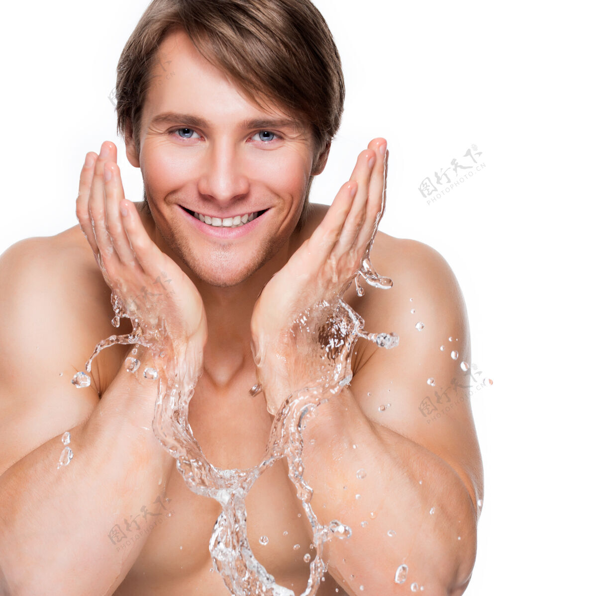 湿一个英俊的微笑的男人用水清洗他健康的脸的肖像-隔离在白色上水疗运动员躯干