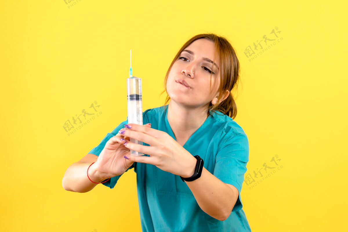 注射黄色墙上的女兽医拿着针剂的正视图持有女兽医成人
