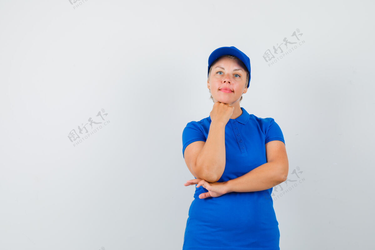 道具穿着蓝色t恤的成熟女人把下巴撑在高举的拳头上 看起来很理智姿势活跃提高