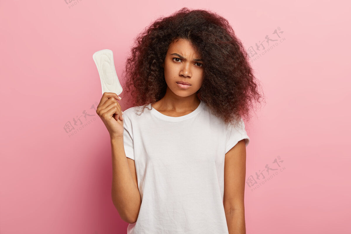 个人愁眉苦脸的非裔美国妇女关心个人卫生 拿着卫生巾阴郁妇科非洲
