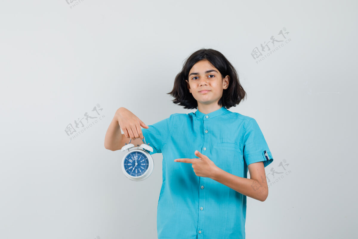 保证穿蓝色衬衫的女学生指着时钟 看上去很自信大学休闲青少年