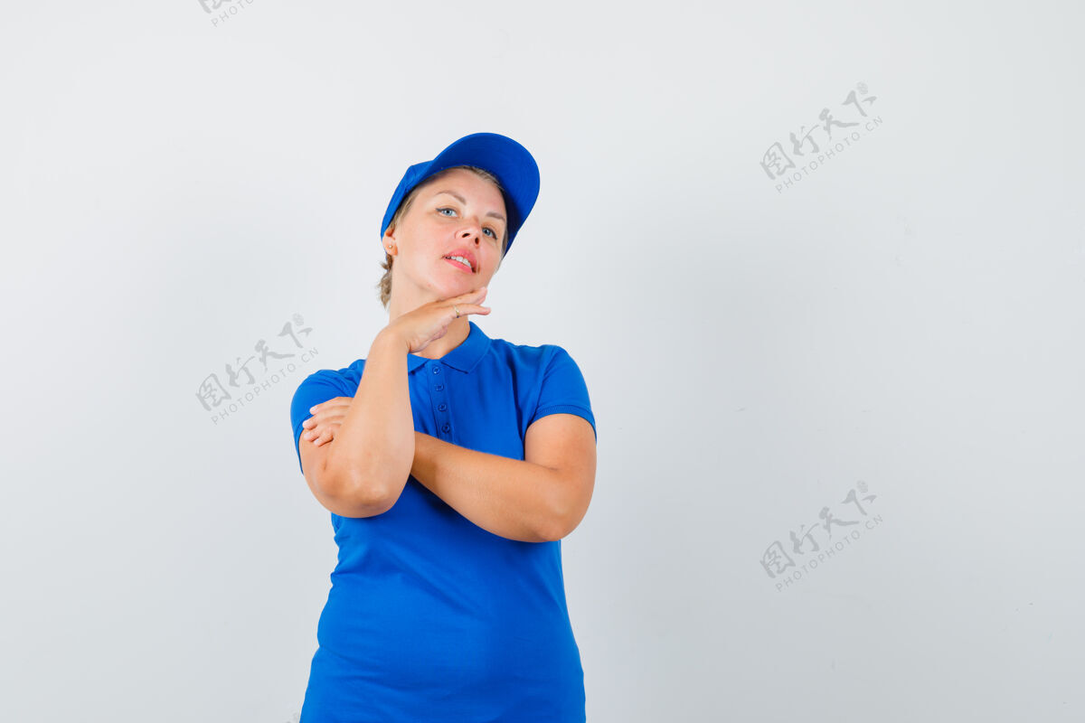 触摸穿着蓝色t恤的成熟女人抚摸着下巴上的皮肤 看起来很可爱皮肤帽子女人