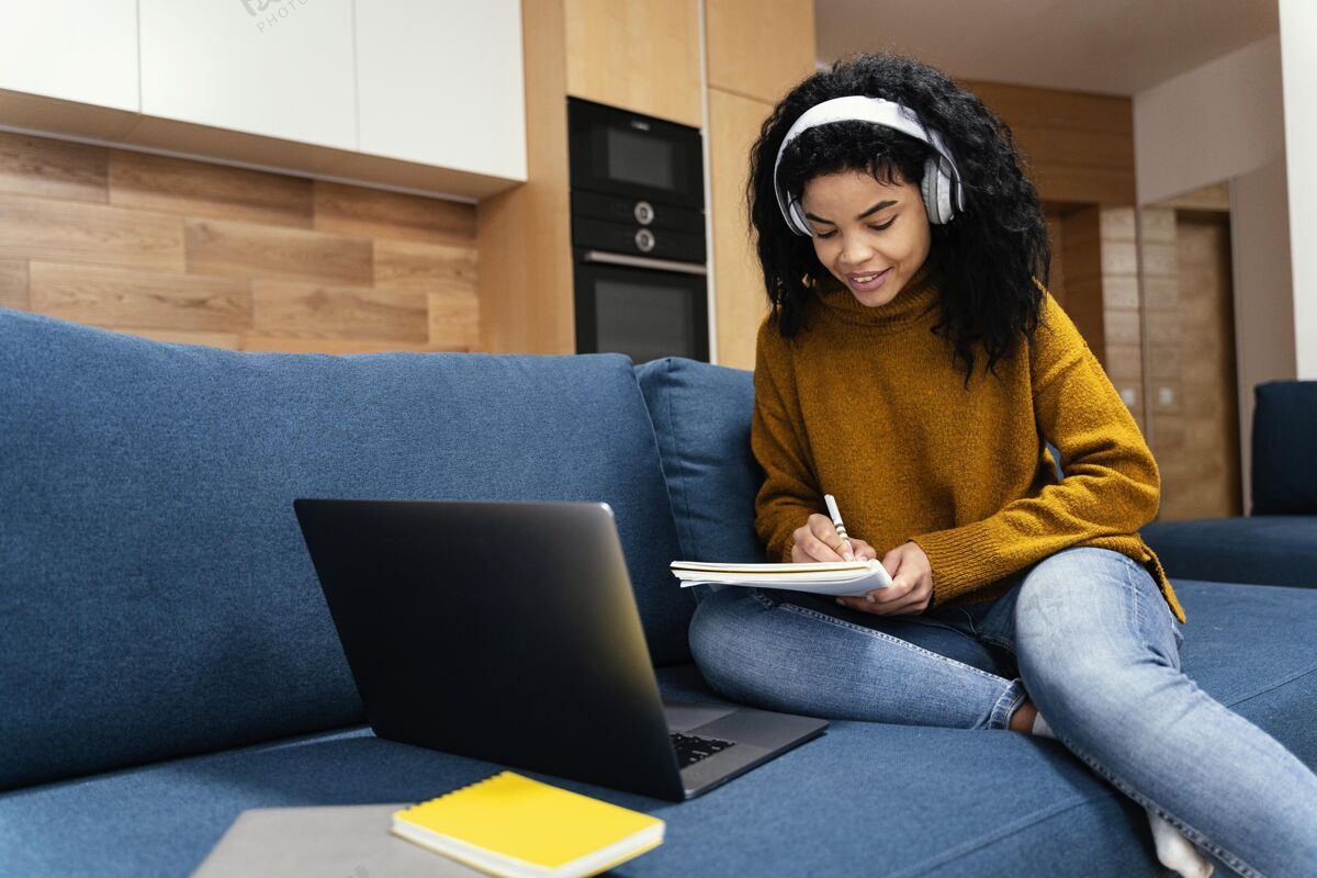 笔记本电脑十几岁的女孩与笔记本电脑和耳机在网上上学班级学习学习