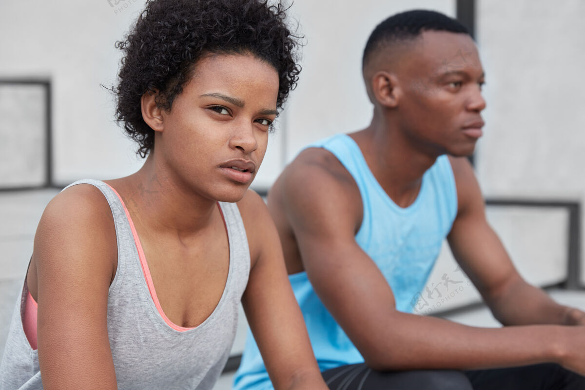 侧严肃的黑人少女和男子穿着休闲背心 在户外休息 有自信的面部表情 为体育比赛做准备健康的生活方式理念思维跑步观点