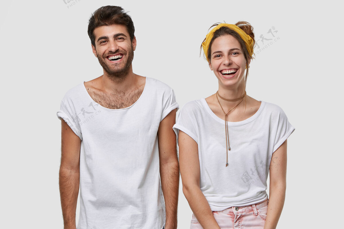 风格身着白色模拟t恤的快乐男女 笑容灿烂 神采奕奕 站得很近 隔墙而过同事牙齿立场