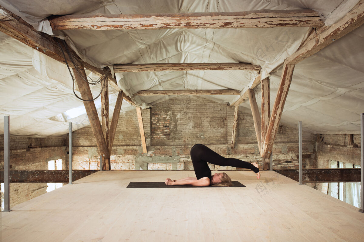 身体柔软一个年轻的女运动员在废弃的建筑上练习瑜伽心理和身体健康平衡健康的生活方式 运动 活动 减肥 专注的概念年轻户外专注