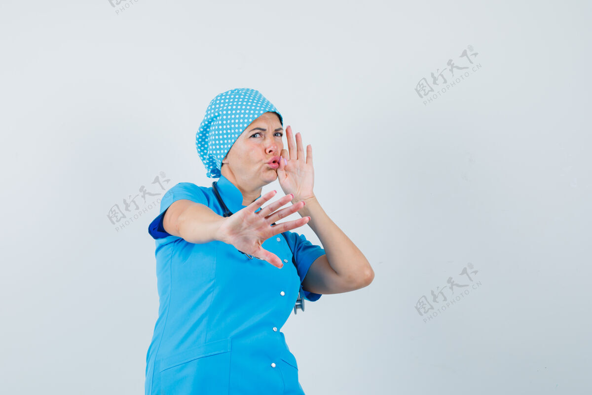 诊断女医生表现出停止的姿态 嘴巴闭上拉链 穿着蓝色制服 看起来很害怕 前视图护士职员手势