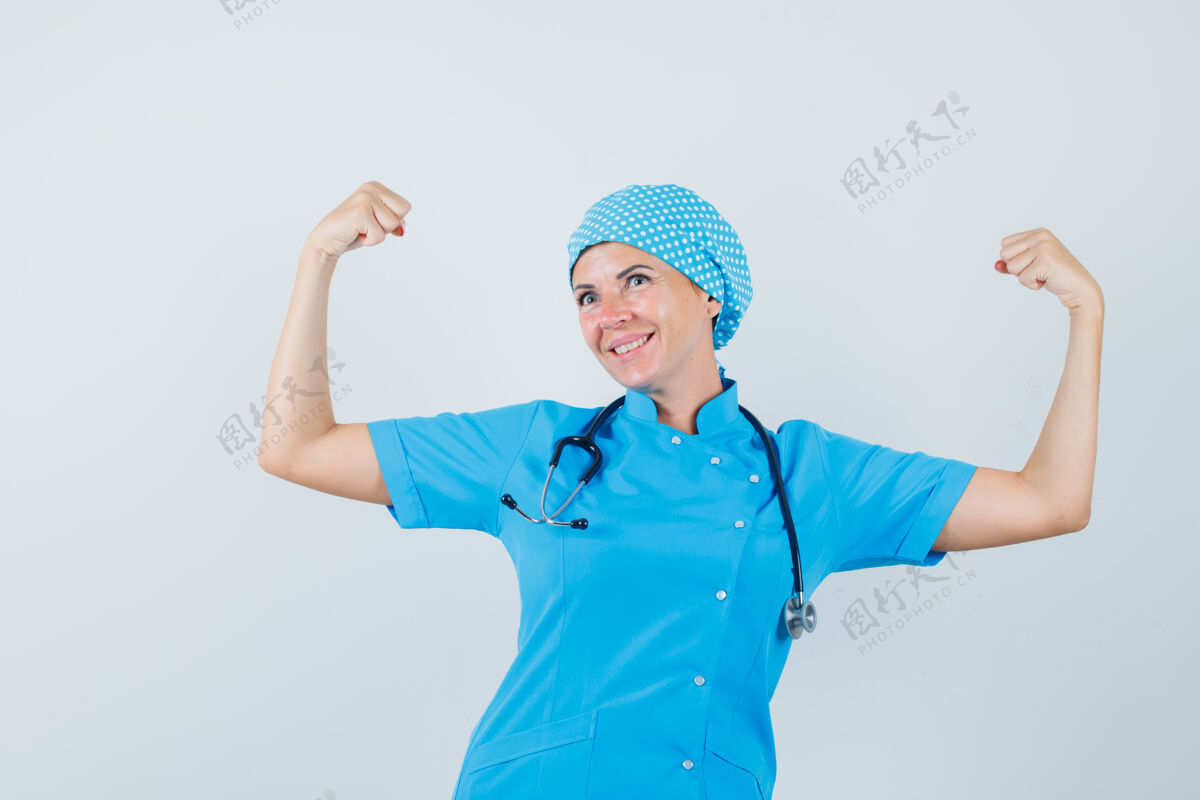 病人身着蓝色制服的女医生展示手臂肌肉 看上去很自信 正面图疾病肌肉外科医生