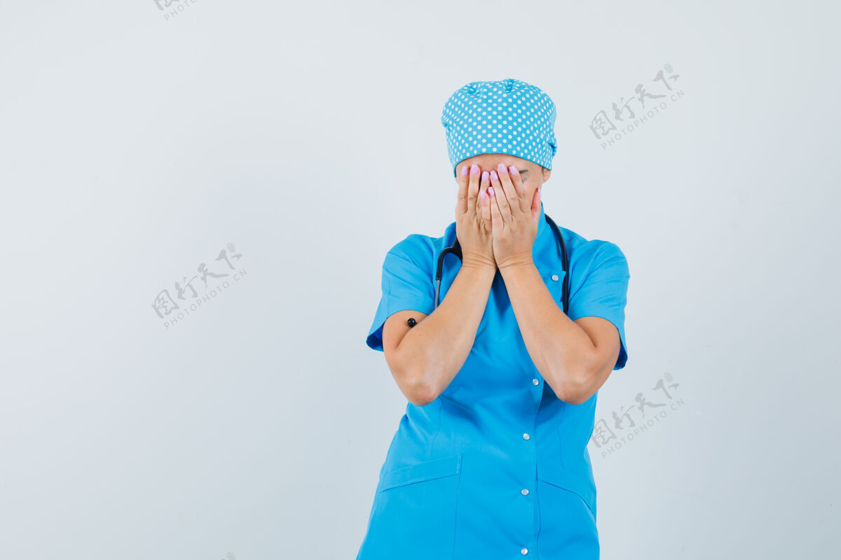 工作人员女医生用手捂住脸 穿着蓝色制服 看上去很沮丧正视图制服疾病诊所