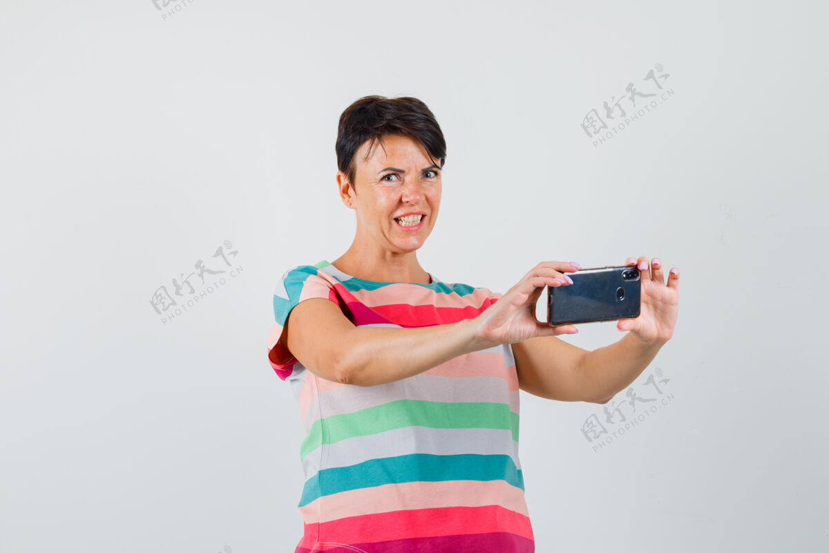 面罩女性穿着条纹t恤在手机上拍照 看起来很恼火前视图手机护士条纹