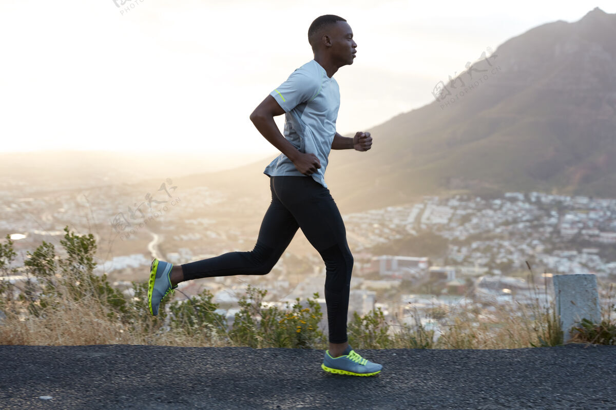 决心户外拍摄的活跃的黑皮肤男子上午跑步 有规律的训练 穿着运动服和舒适的运动鞋 集中到远处 看到终点很远路线人乡村