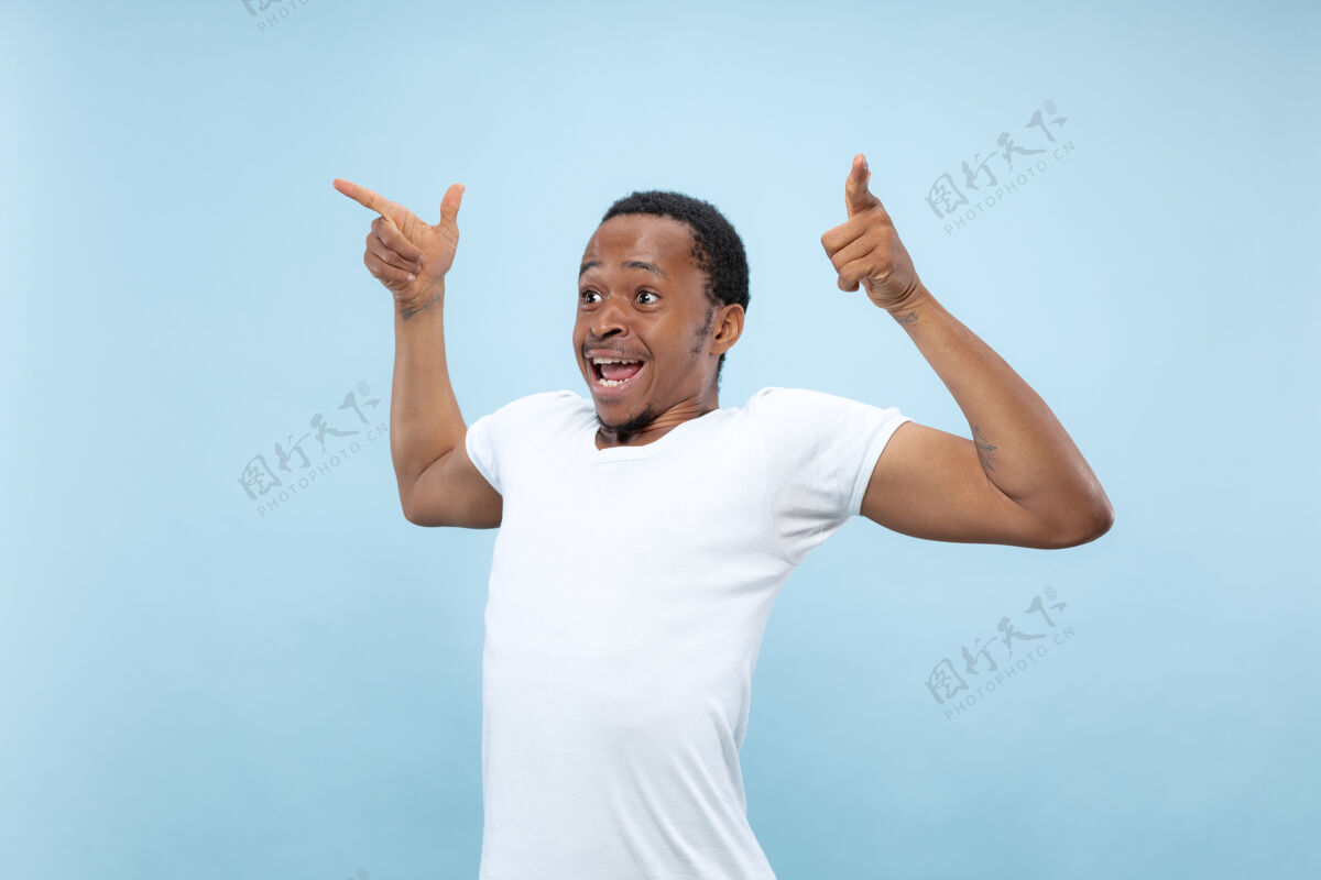 胡须半身特写 蓝色背景 身穿白衬衫的非洲裔美国青年人类情感 面部表情 广告 概念庆祝 惊讶 惊讶 震惊 疯狂的快乐看企业家肖像