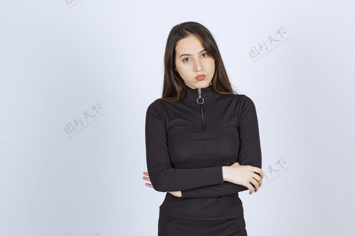 冷静穿黑色衣服的女孩摆出专业的中性姿势 没有任何反应成熟严格年轻