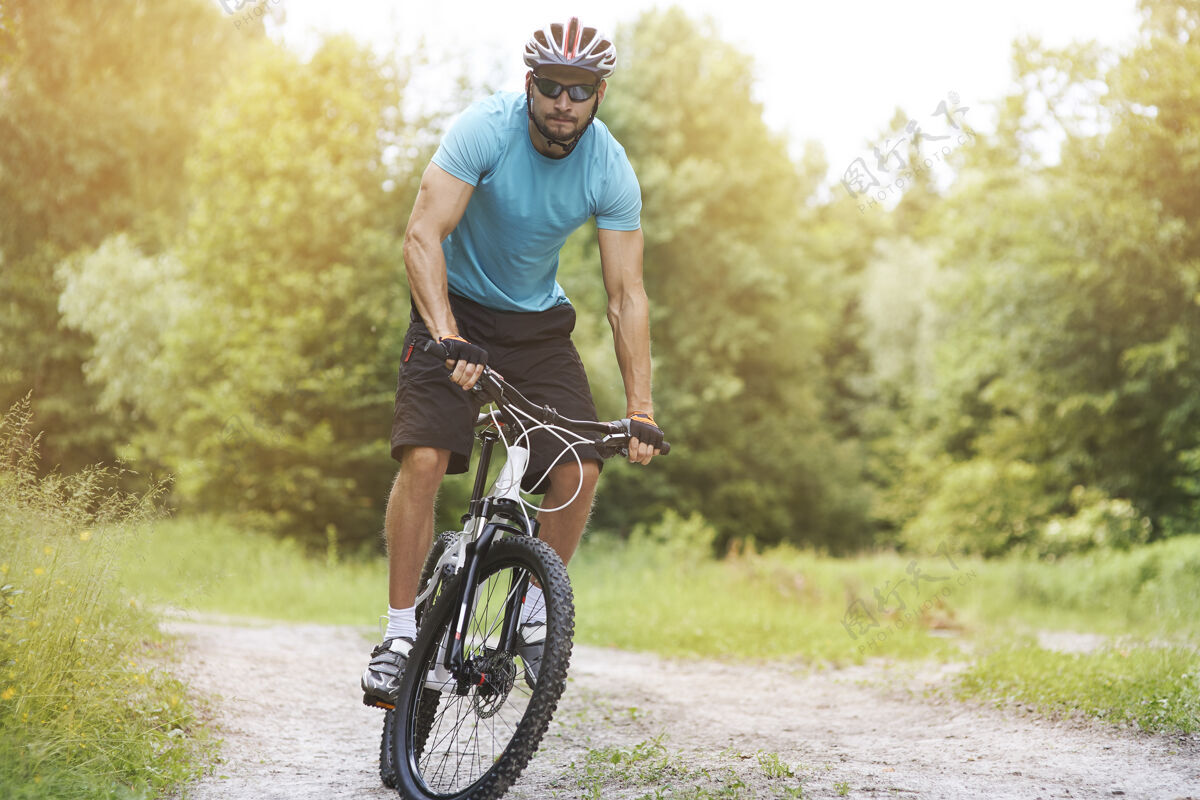 运动在森林里骑自行车的业余选手站健康的生活方式骑
