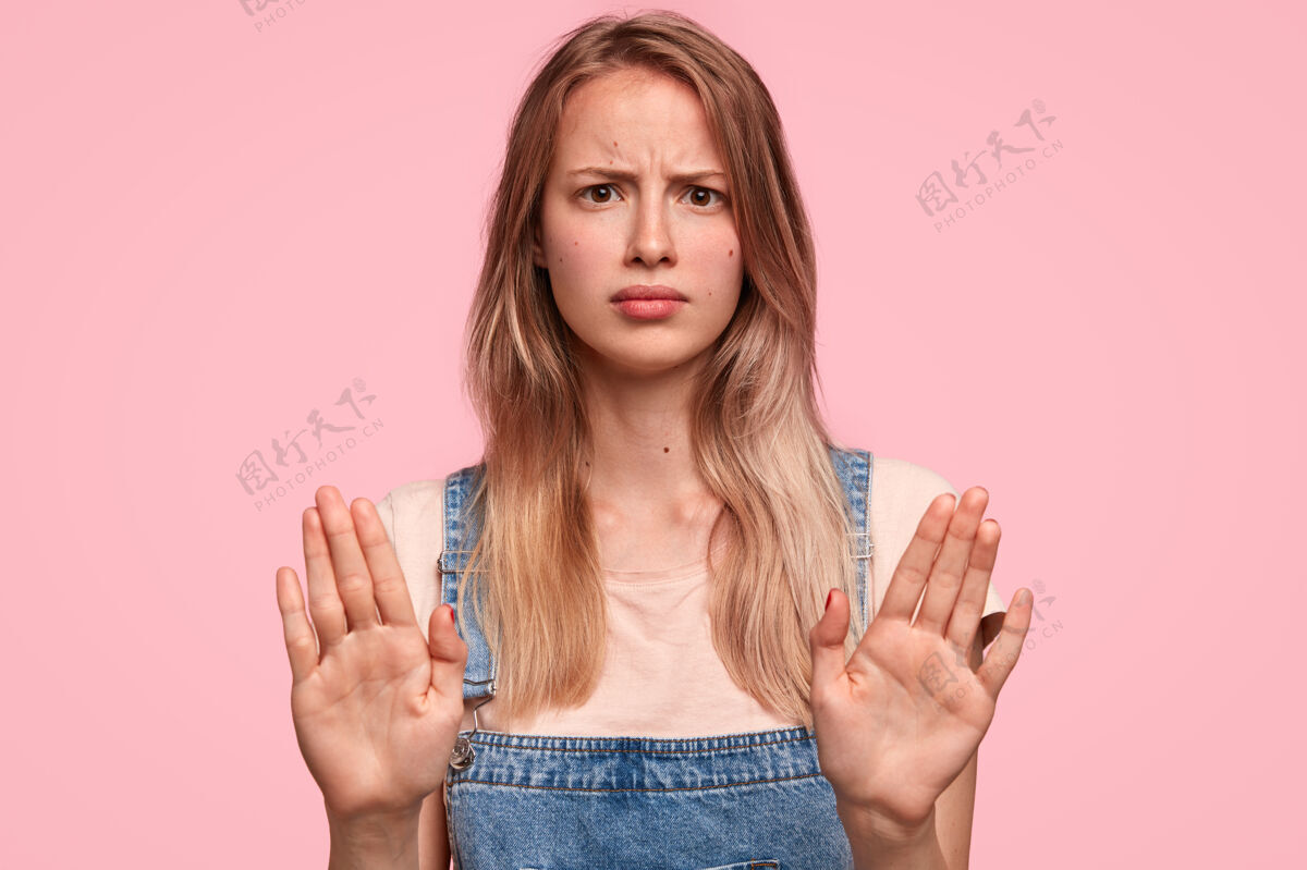 手掌带着恼怒表情的脾气暴躁的年轻女性的摄影棚镜头吸引射击限制