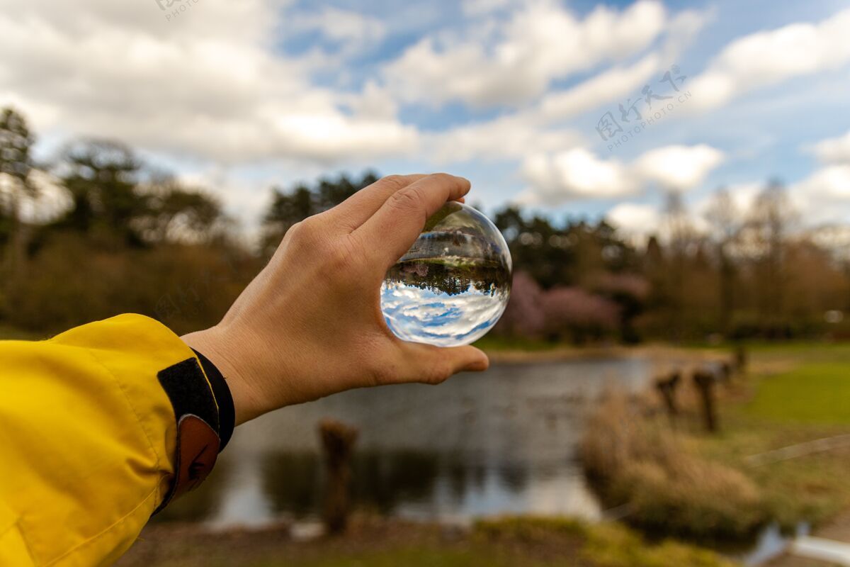光手拿着一个玻璃球在大自然中特写自然圆