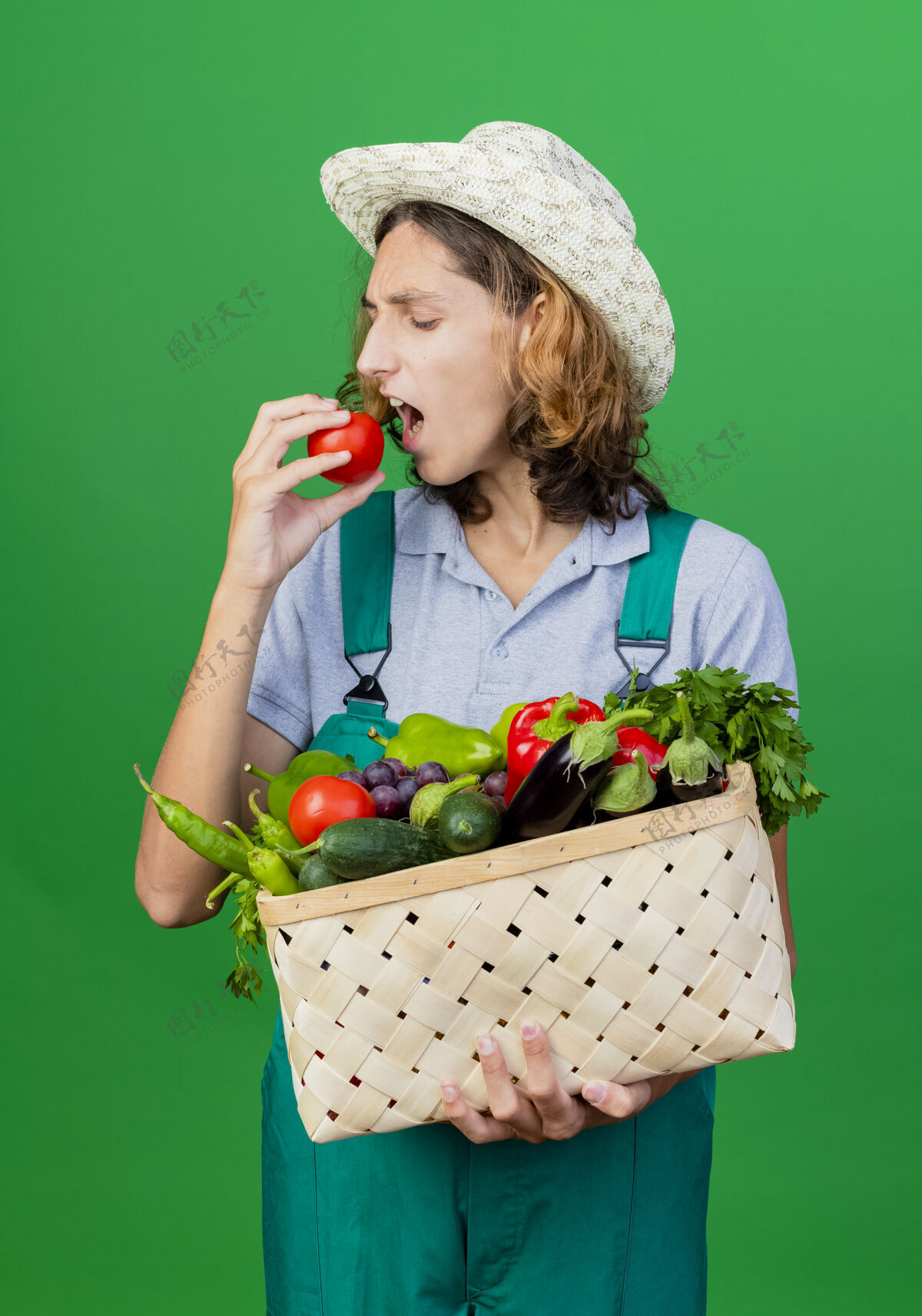 连体衣年轻的园丁穿着连体衣戴着帽子拿着装满新鲜蔬菜的箱子板条箱新鲜男人