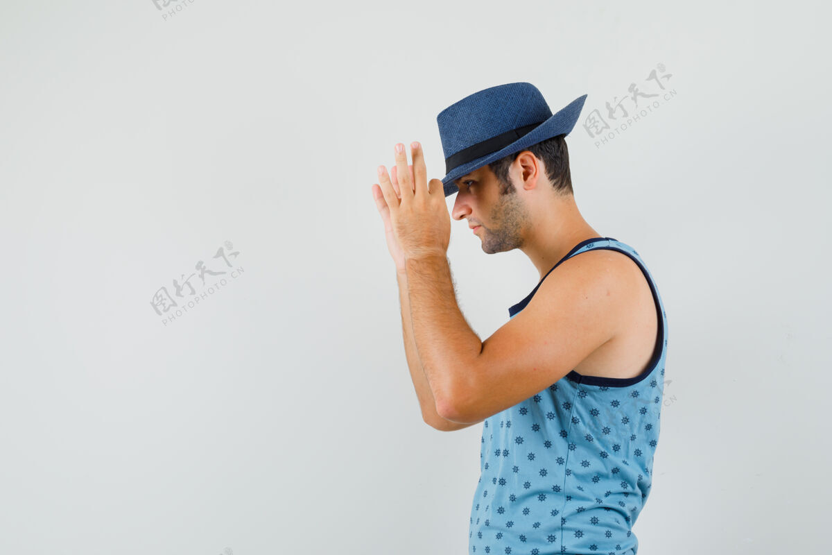 朋友年轻人用手指抚摸着帽子 穿着蓝色单品 看起来很帅聪明年轻模特