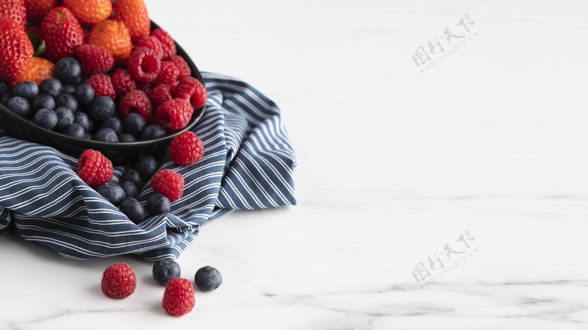 复制空间高角度的碗与草莓 覆盆子和蓝莓美味小吃水果