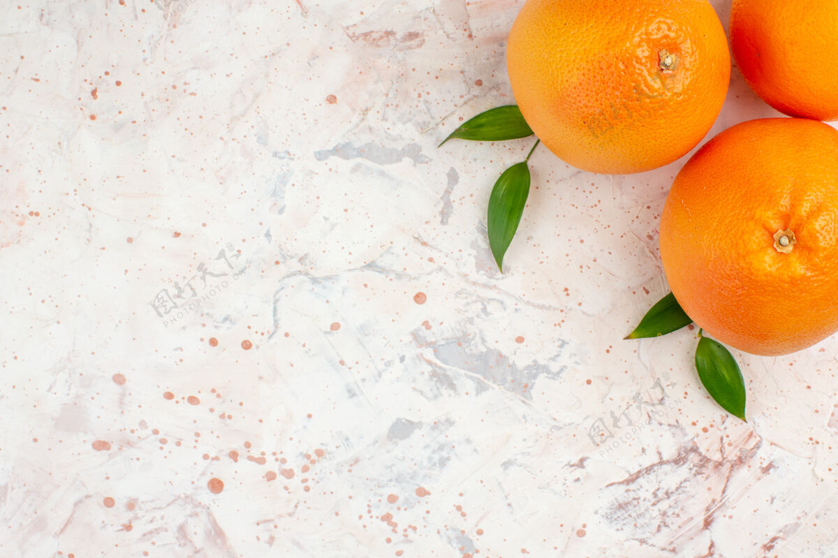 果汁在明亮的表面上俯瞰新鲜的橙子 有自由空间柑橘柑橘叶