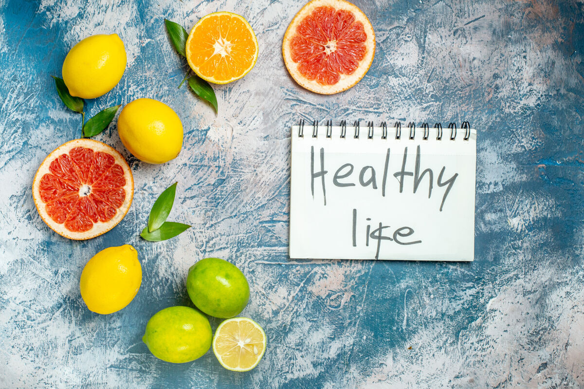 写作俯视图切柚子柠檬健康生活写在蓝白色表面的记事本上水果顶部维生素