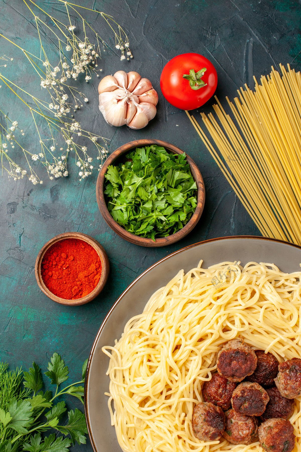 面团俯视图煮熟的意大利面食 深蓝色表面有肉丸和绿色烹饪面食盘子