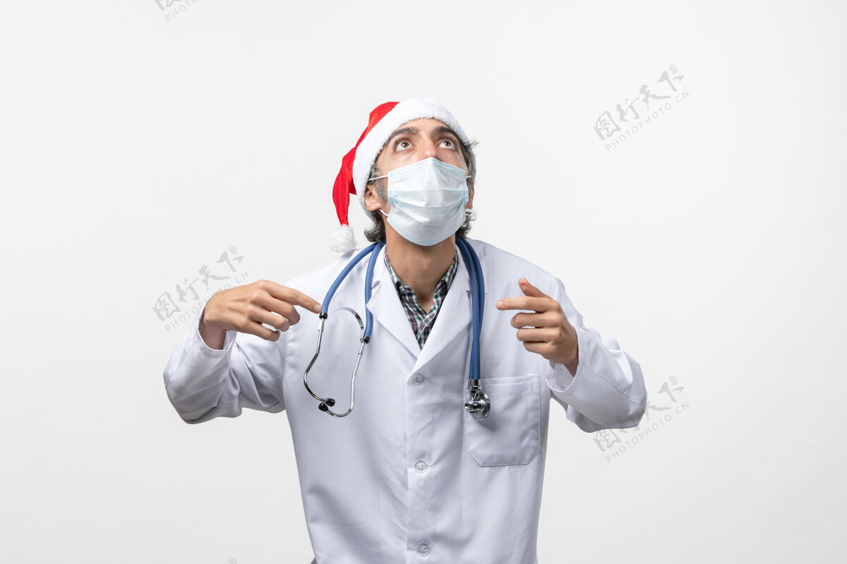 大流行正面图白色办公桌上戴口罩的男医生假日病毒大流行外套制服医生
