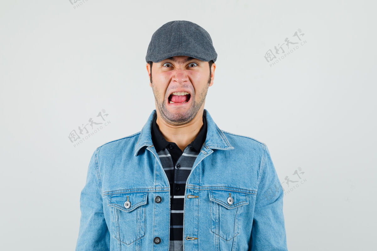 发型年轻人戴着帽子 t恤 夹克看着摄像机 神情紧张胡须交叉现代