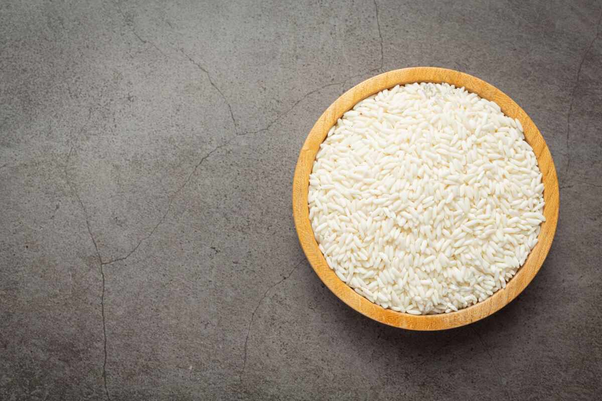营养白米饭放在深色地板上的小木盘上营养健康饮食