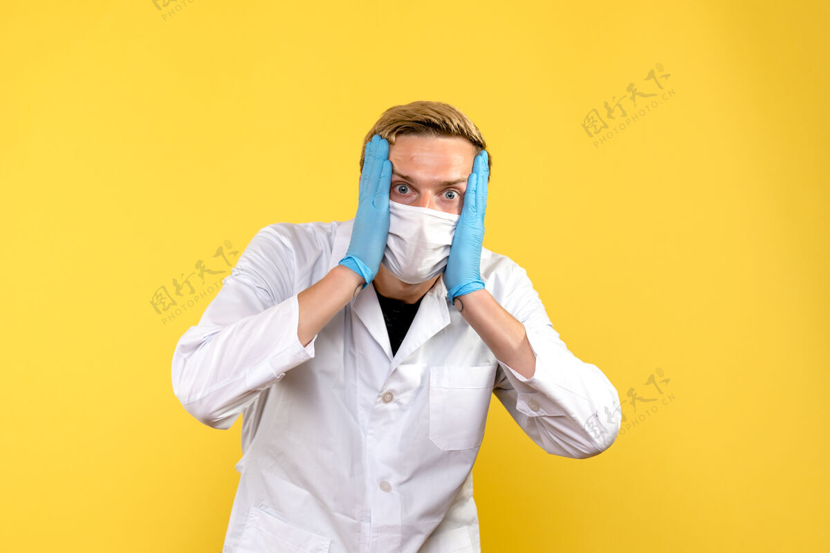 专业人士正面图年轻男医生强调黄色背景大流行医疗卫生科维德服装医生外套