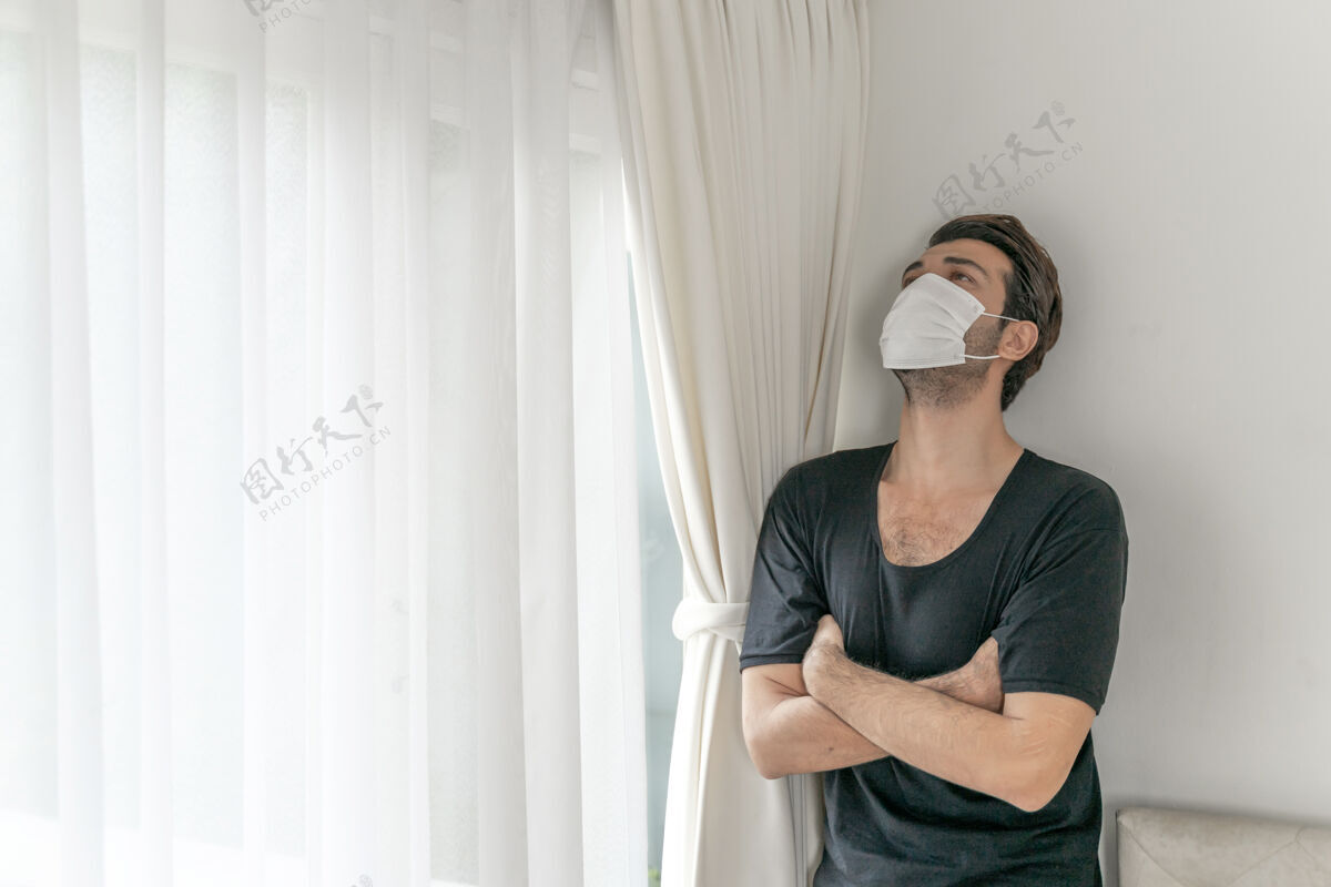 男性在检疫室戴口罩以防因冠状病毒冠状病毒-19引起头痛和咳嗽白天传播咳嗽