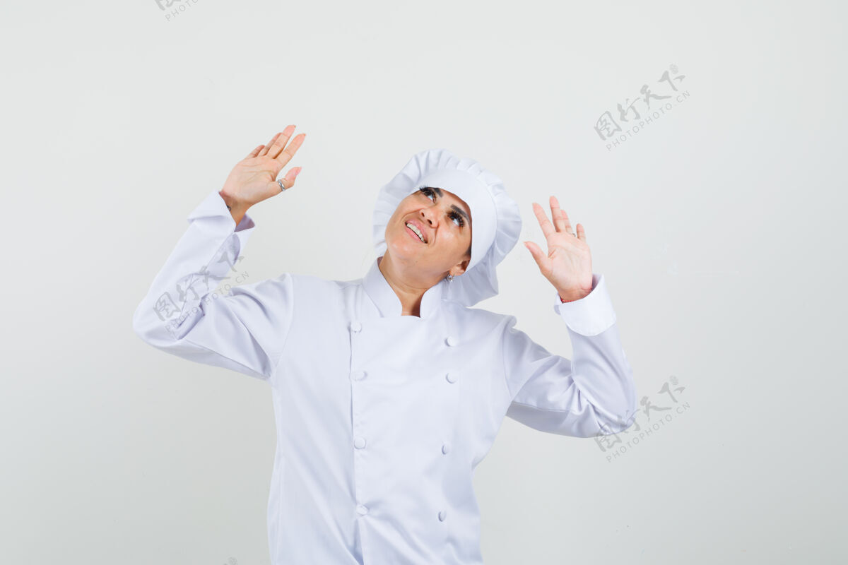 烹饪女厨师抬起头来 双手举着白色制服 看上去很高兴美食餐厅棕榈