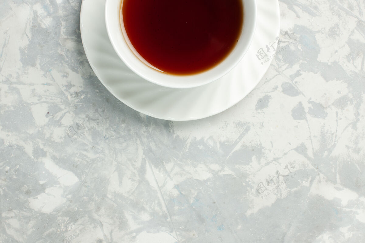 茶托顶视图浅白色表面上的一杯热茶杯子咖啡因饮料