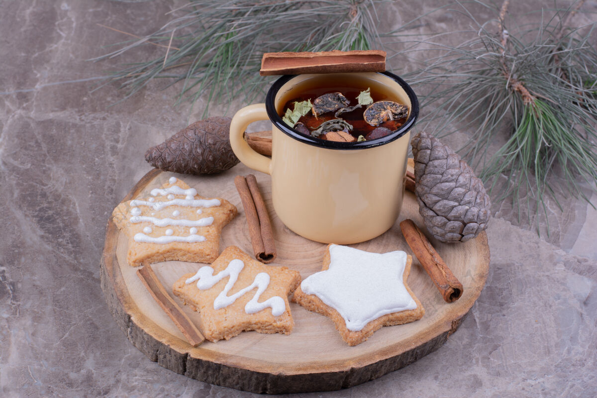 假日一杯凉茶加姜饼在木板上脂肪面粉糕点