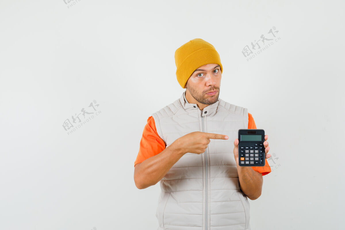 指点年轻人指着计算器 穿着t恤 夹克 戴着帽子 表情严肃正面图计算器发型成功