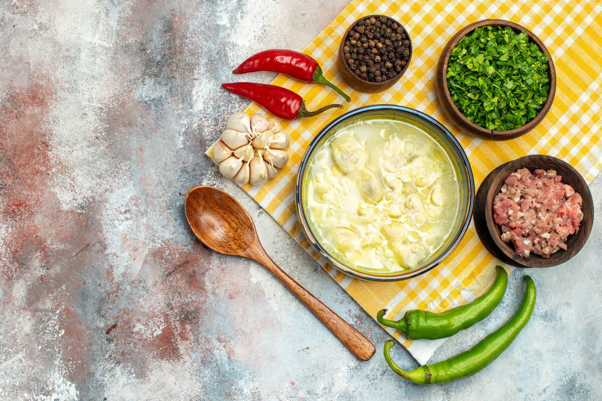 午餐俯瞰杜什巴拉饺子汤碗大蒜辣椒木勺碗肉椒和绿色裸体表面与复制空间勺子晚餐观点