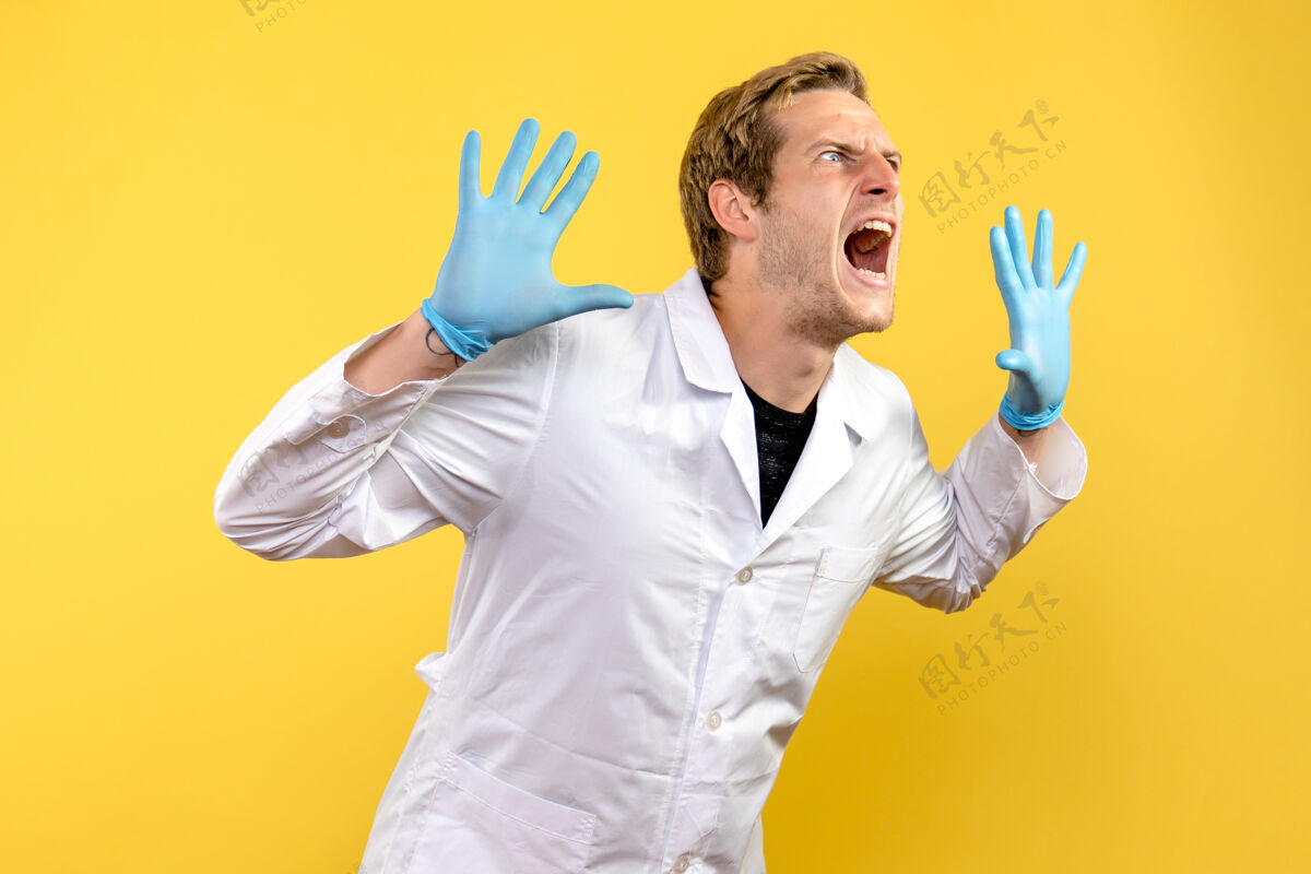 实验室外套前视图年轻男性医生在黄色背景下尖叫人类病毒医疗大流行正面人类医生