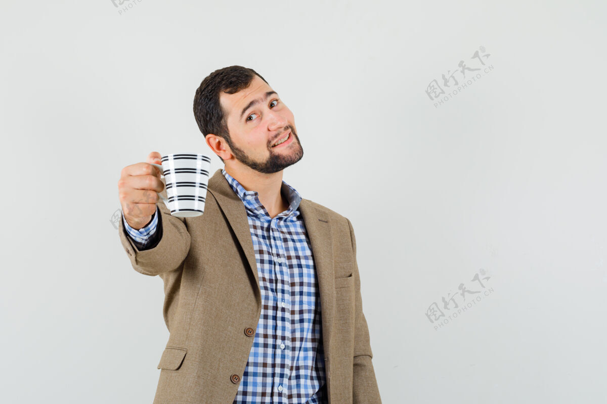 英俊年轻人提供一杯咖啡在衬衫 夹克衫和看起来温柔前视图聪明咖啡休闲