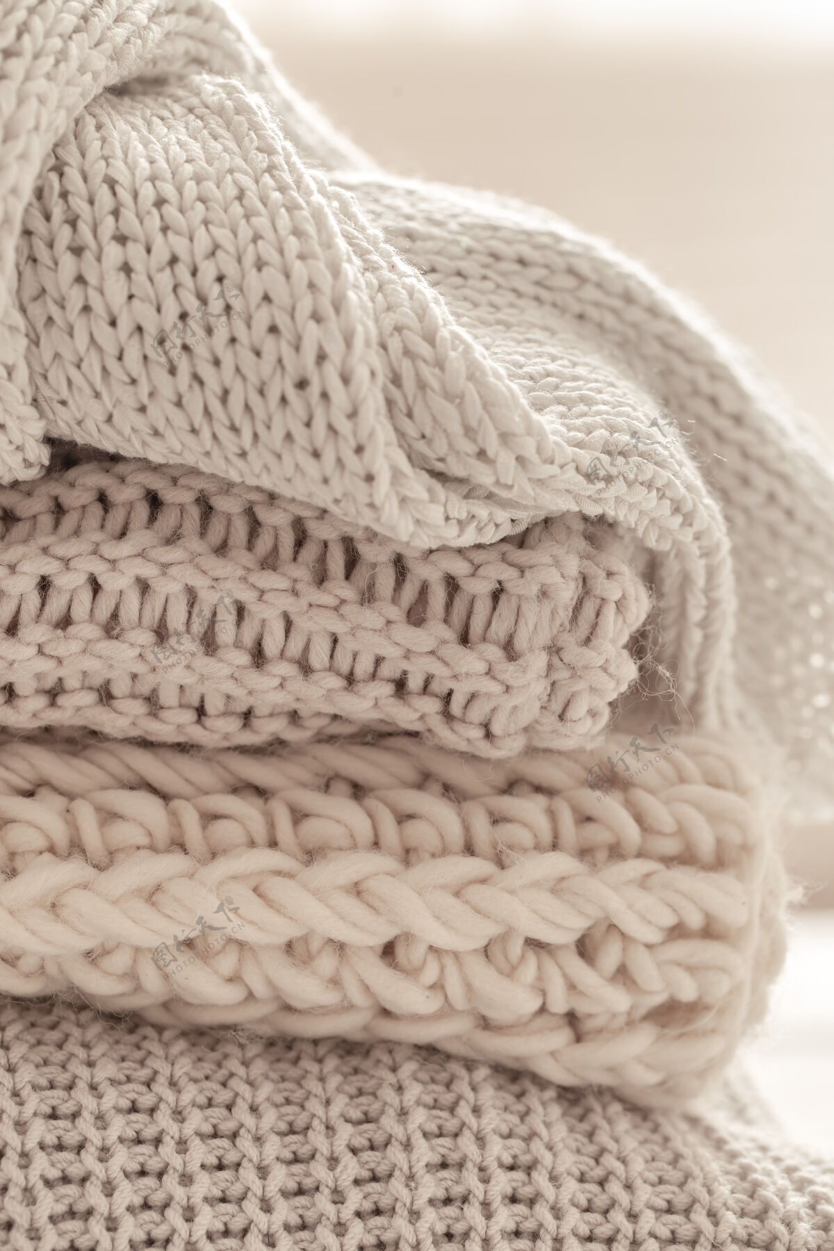 针织在模糊的白色背景上有一堆温暖的针织物围巾冬季针织品