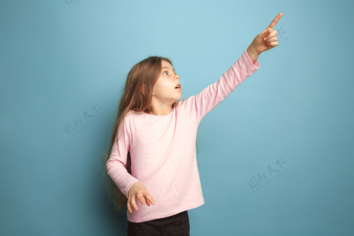 人决定和选择严肃的少女在蓝色上竖起手指面部表情和人们的情感概念严肃随意表情