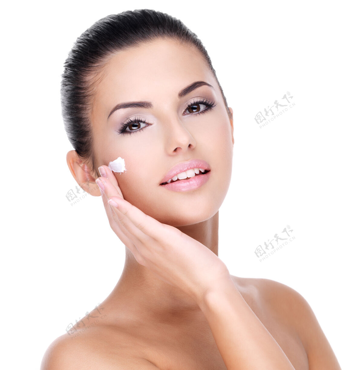 白色背景年轻女子用化妆霜在一张漂亮的新鲜脸上-隔离在白色有吸引力人皮肤