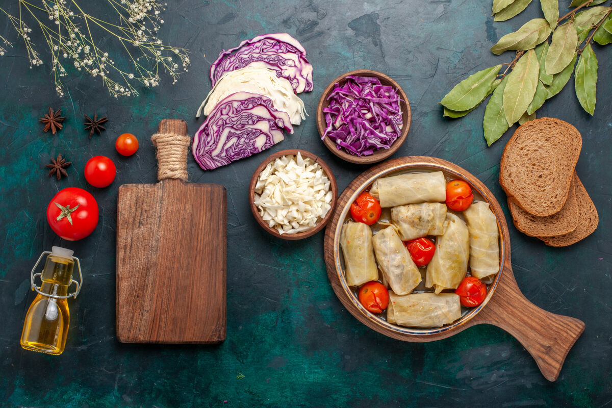 盘子俯瞰图美味的肉食卷心菜和西红柿称为油在深蓝色的桌子上多尔玛肉美味