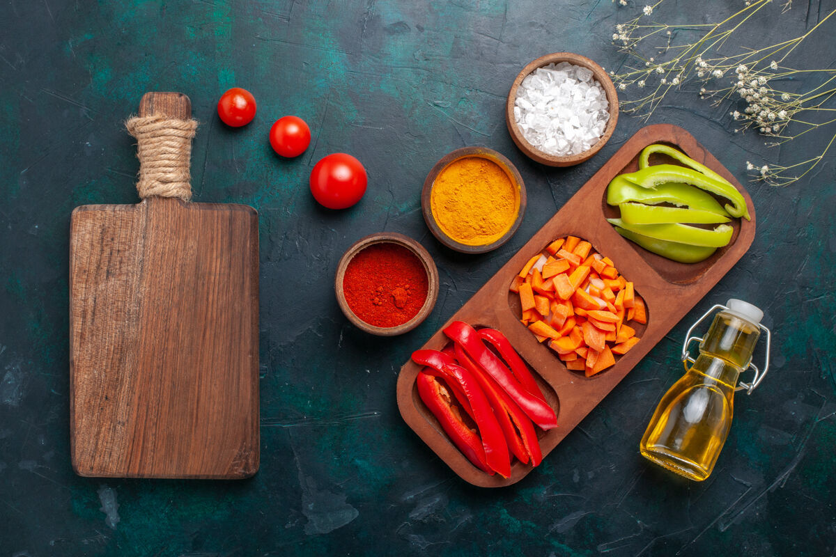 午餐顶视图切甜椒与调味品和橄榄油在深蓝色的背景饮食油健康